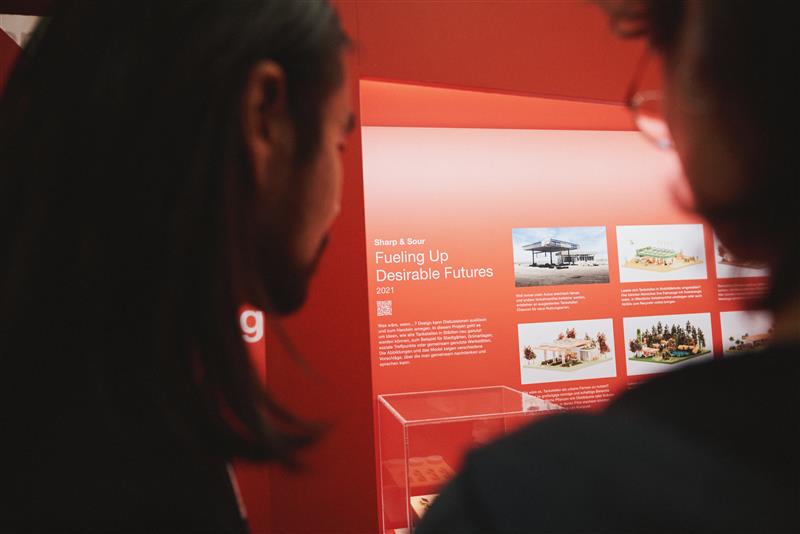 25_design_connects_1663 Zwei Menschen sehen sich ein Exponat der bayern design Ausstellung an